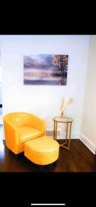 a living room with a yellow chair and a table at Lovely 1-bedroom rental unit with free parking in Washington
