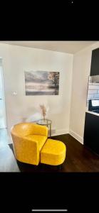 a yellow ottoman sitting in a room with a table at Lovely 1-bedroom rental unit with free parking in Washington