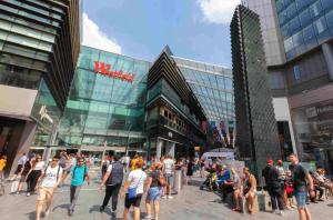 una multitud de personas caminando delante de un edificio en Stratford city apartments, en Londres