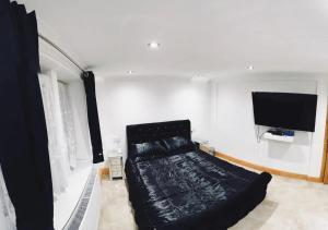 a living room with a couch and a flat screen tv at Stratford city apartments in London