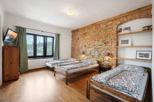 a room with three beds and a brick wall at Apartman Belavita in Banská Štiavnica