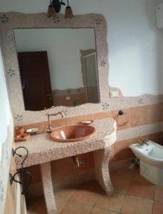 bagno con lavandino, specchio e servizi igienici di Casa nel verde a Cannole
