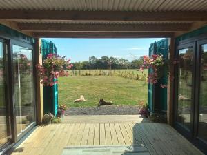 un porche abierto con vistas a un campo en Bluebell Cabin, en Badsey