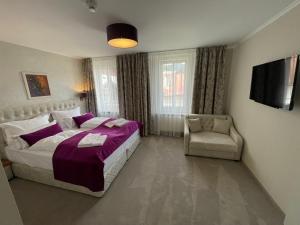 sypialnia z dużym łóżkiem i krzesłem w obiekcie Hotel Radetzky w mieście St. Gilgen