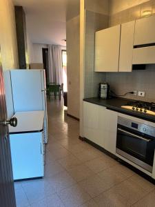 una cucina con frigorifero bianco e piano cottura di fior di loto a Desenzano del Garda