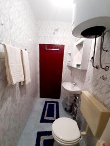 a bathroom with a white toilet and a red door at Oaza in Komarna +22 photos