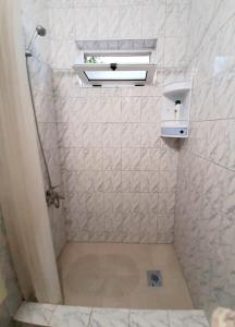 a small bathroom with a shower with a window at Oaza in Komarna
