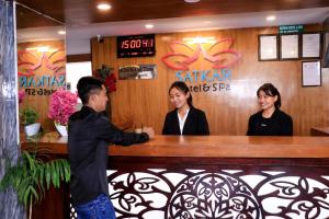 a man standing at a counter in a restaurant at Satkar Hotel and Spa in Kathmandu