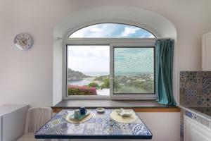 a dining room with a table and a window at sole chiaro home in Procida