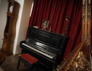 プレデアルにあるHotel Art Montanaの赤いカーテン付きの部屋のピアノ