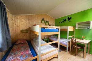 a bunk bed room with two bunk beds and a desk at Hof-Tschannen in Lengwil