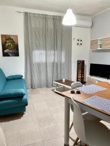 salon ze stołem i niebieską kanapą w obiekcie Seaside village Catania w Katanii