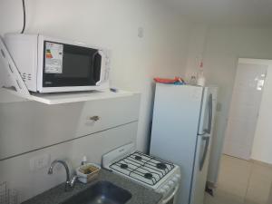 una cocina con un microondas encima de un refrigerador en El Serrano, en Tandil