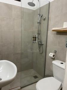 a bathroom with a shower with a toilet and a sink at Eco Beach And Magic Garden Hotel in Gennadi