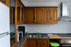 una cucina con armadi in legno e lavandino di Beautiful Málaga House - Holidays a Málaga
