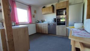 a large kitchen with wooden cabinets and appliances at Ferienhaus Rudolf in Achberg