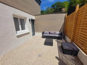 a patio with a purple bench and a fence at La Volcane - Maison au calme des Bois Royaux in Le Chesnay