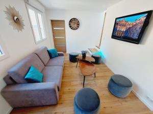 a living room with a couch and a table at La Volcane - Maison au calme des Bois Royaux in Le Chesnay