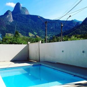 una piscina con una montaña en el fondo en Casa morada na serra, en Macaé