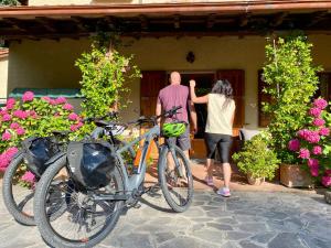 a man and a woman standing outside a house with a bike at Da Ronald ... A Pian Del Papa in Pratovecchio