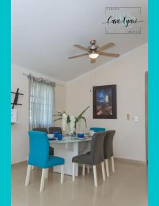 a dining room table with blue chairs and a ceiling fan at Casa Ayari - 3 Habitaciones - 2 a 6 personas - WIFI- AC in Cancún