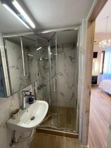 W łazience znajduje się umywalka i przeszklony prysznic. w obiekcie AF Guest House w mieście Areopolis