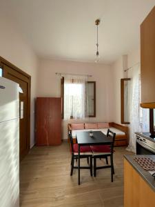 eine Küche und ein Wohnzimmer mit einem Tisch und einem Sofa in der Unterkunft AF Guest House in Areopoli