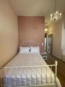 ein Schlafzimmer mit einem großen Bett mit einem Kronleuchter in der Unterkunft AF Guest House in Areopoli