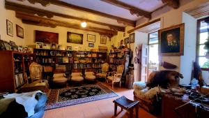 uma sala de estar com um cão sentado numa sala com estantes de livros em Hacienda San Isidro De Iltaqui em Cotacachi