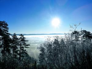 uma vista do topo de uma montanha com o sol acima das nuvens em Appartement La Bernardine au coeur du Jura em Orgelet