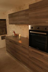 una cocina con armarios de madera y horno negro en Casa Carlotta: Aradeo - 15 minuti da Gallipoli, en Aradeo