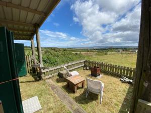 a patio with a table and chairs and a fence at Stunning views & sunrises from Sally Saracen in St Ives