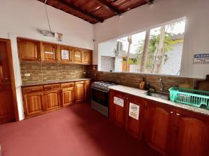 a kitchen with wooden cabinets and a window at Hostal Vista al Mar in Puerto Ayora