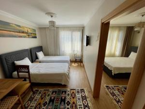 イスタンブールにあるOldtown Sultanahmet Suitesのベッド2台とリビングルームが備わるホテルルームです。