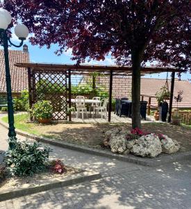 a gazebo with a table and chairs under a tree at Bed And Breakfast Olimpia in San Salvatore Monferrato