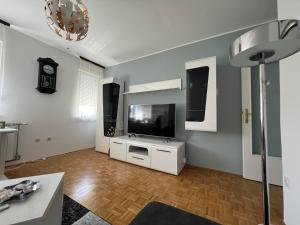 a living room with a flat screen tv on a wall at Stan u centru Čakovca s pogledom na park in Čakovec
