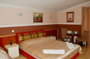 - une chambre avec un lit, une table et des chaises dans l'établissement Uni Palas, à Kavadartsi