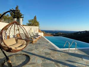 a swing sitting on a patio next to a swimming pool at Tou Mikrou Voria in Agios Petros