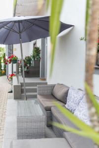 salon z kanapą i parasolem w obiekcie Orchideen Apartment w Villach