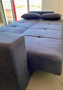 - un grand lit bleu avec des oreillers dans l'établissement Appartamento 4/5 persone., à Roseto degli Abruzzi