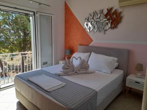 ein Schlafzimmer mit einem Bett mit weißen Kissen und einem Balkon in der Unterkunft Sunrise View House in Poros