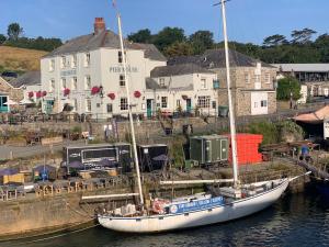 a boat docked in the water in front of a building at Sea Haze Charlestown in St Austell