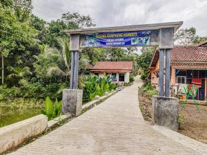 un cartello alla fine di un sentiero di fronte a un edificio di OYO Homes 91114 Desa Wisata Bangunharja a Banjar