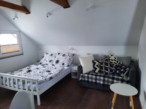 Habitación pequeña con sofá y cama en Apartament na górce, en Uherce Mineralne