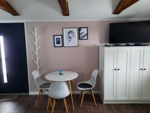 una sala da pranzo con tavolo, sedie e TV di Apartament na górce a Uherce Mineralne