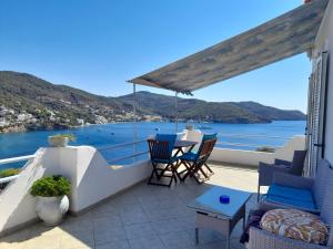 a balcony with a table and chairs and a view of the water at Sunrise View House in Poros