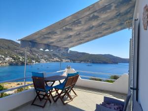 a balcony with a table and chairs and a view of the water at Sunrise View House in Poros