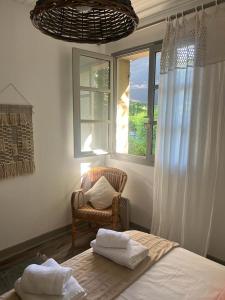 Un dormitorio con una cama y una silla y una ventana. en Chambre d'hôtes indépendante à la campagne, en Saint-Just-le-Martel