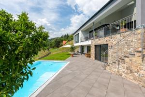 ein Haus mit einem Swimmingpool neben einem Gebäude in der Unterkunft Greim15 --- ganzes Ferienhaus mit Fernsicht, Pool, Wellness in Deutschlandsberg + 37 Fotos