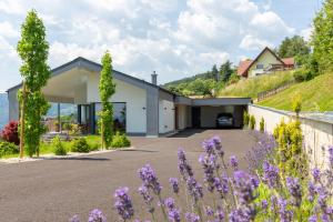 ein Haus auf einem Hügel mit lila Blumen in der Unterkunft Greim15 --- ganzes Ferienhaus mit Fernsicht, Pool, Wellness in Deutschlandsberg